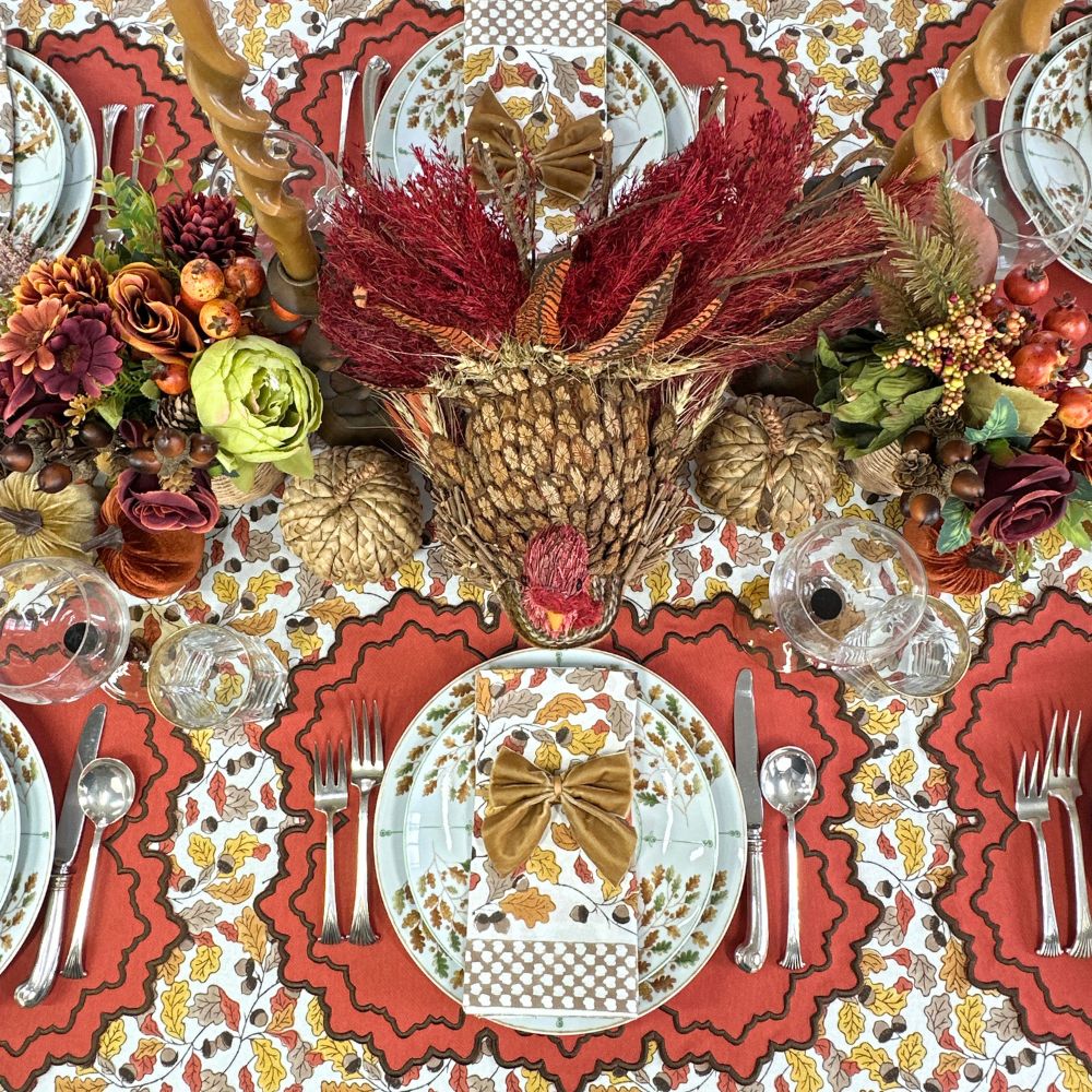 Pumpkin Whitley luxury placemat and napkin on acorn leaves tablecloth with gold napkin bow and Thanksgiving china.