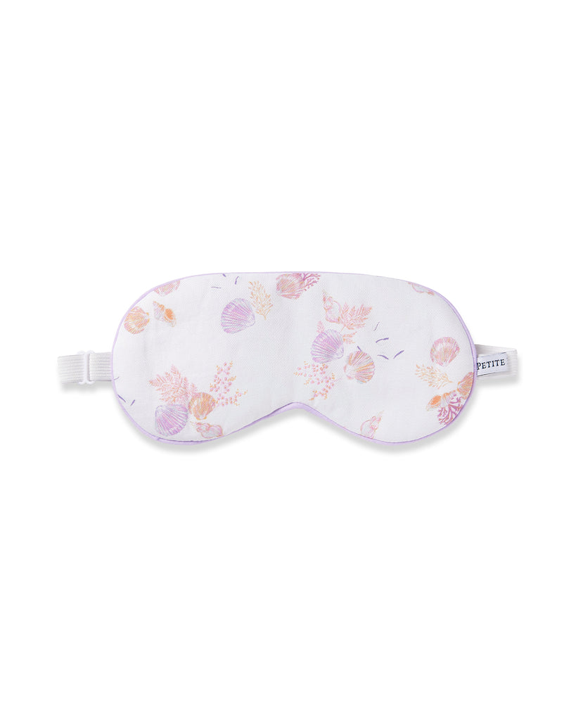The Petite Plume Adults Twill Sleep Mask in Seashell Splendor features a white base with pink and purple seashell patterns, a matching eye mask, a white elastic strap, and refined purple piping. Ideal for monogrammed gifts.