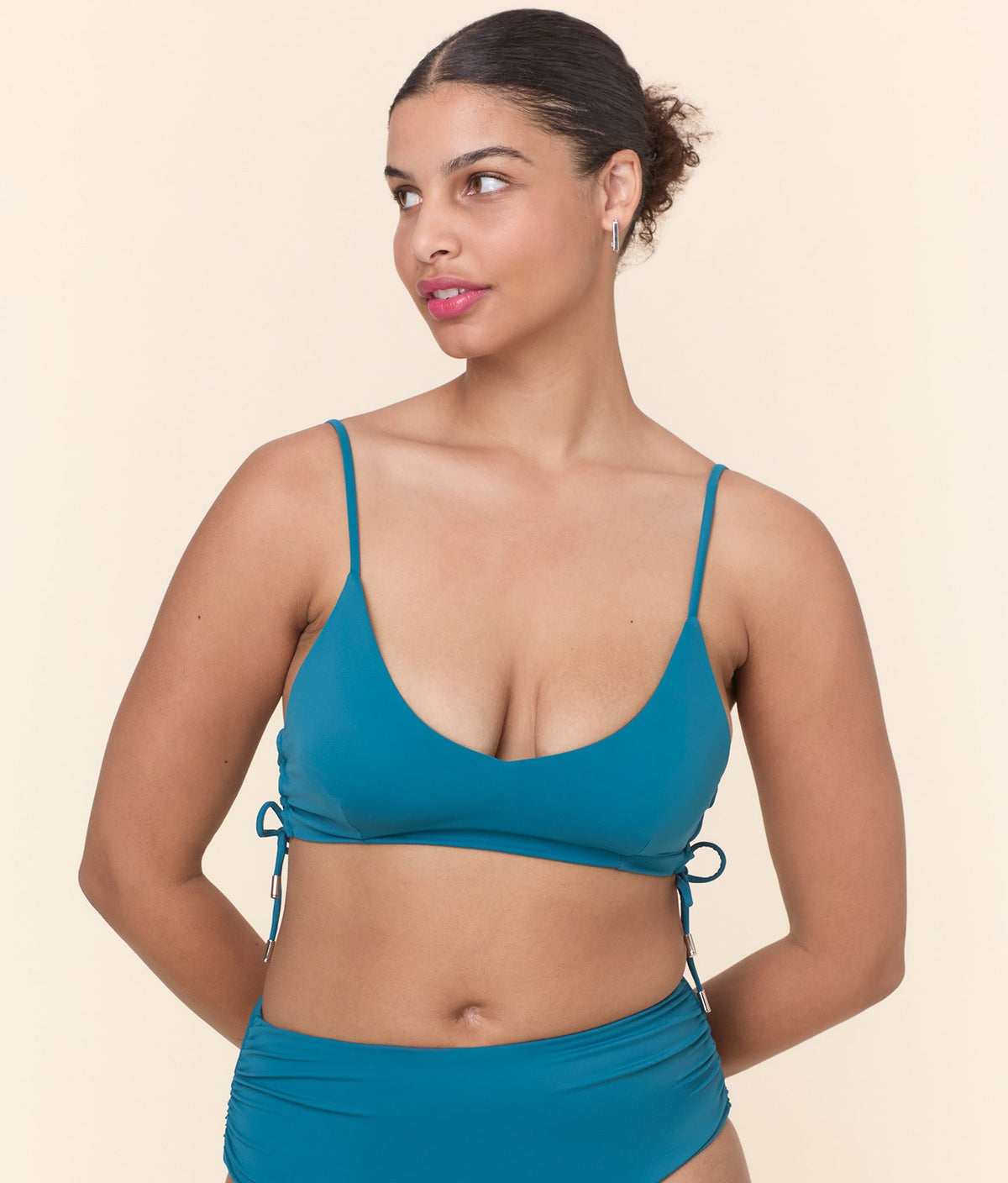Front view of a model in The Elba Bikini Top - Eco Nylon - Ocean, highlighting the soft cups and elegant scoop neckline.