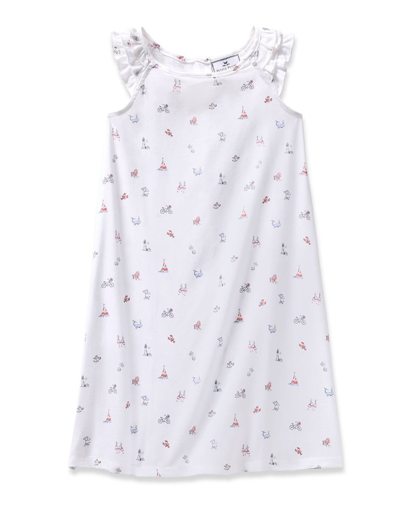 The Girls Twill Amelie Nightgown in Coastal Charms by Petite Plume is a white sleeveless gown with ruffled shoulders, adorned with red and blue illustrations like bikes, Eiffel Towers, and cameras. Made from lightweight cotton, its ideal for wanderlust dreams.