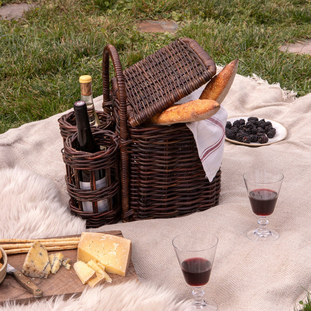 picnic basket on blanket outside with cheese and blackberries