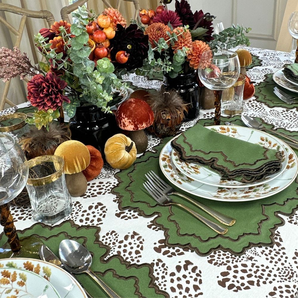 Decorative table setting with autumn-themed centerpieces and place settings. Thanksgiving table, embroidered placemats.