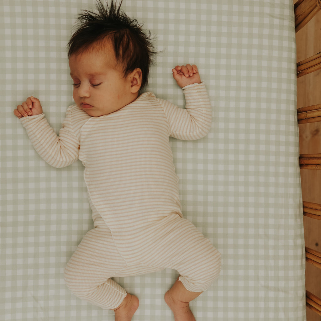 baby sleeping in crib in picnic gingham green print