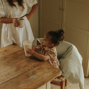 Green Gingham Baby Duvet hanging off chair with child sitting at table