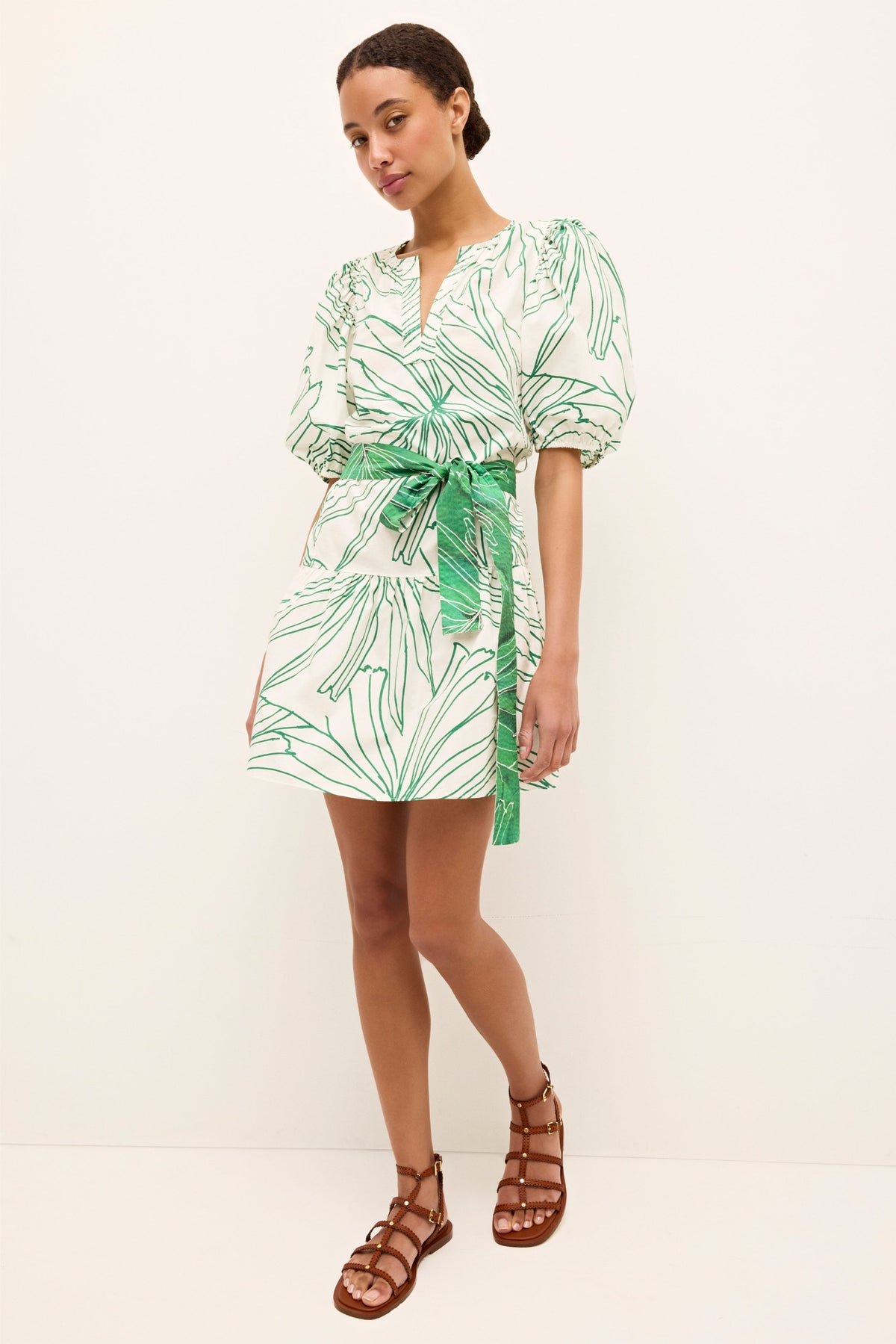 White mini dress with green leaf print, puff sleeves, and matching waist tie