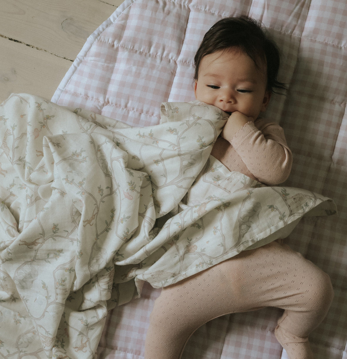 Play Mat in Pink Gingham with baby laying on top with swaddle