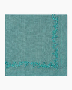 A Prism Vine Dinner Napkin with embroidered leaves, made of linen.