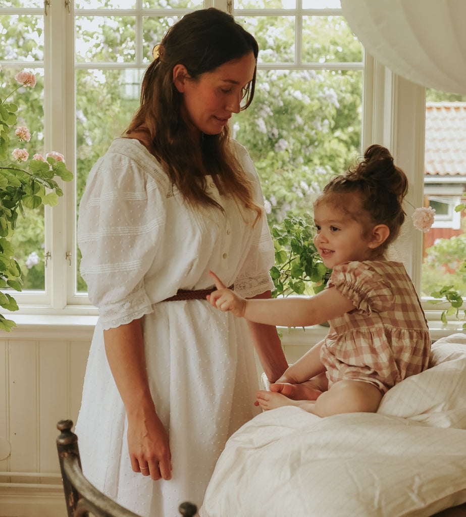 Petal Scallop Baby Duvet with child sitting on top with mother by side