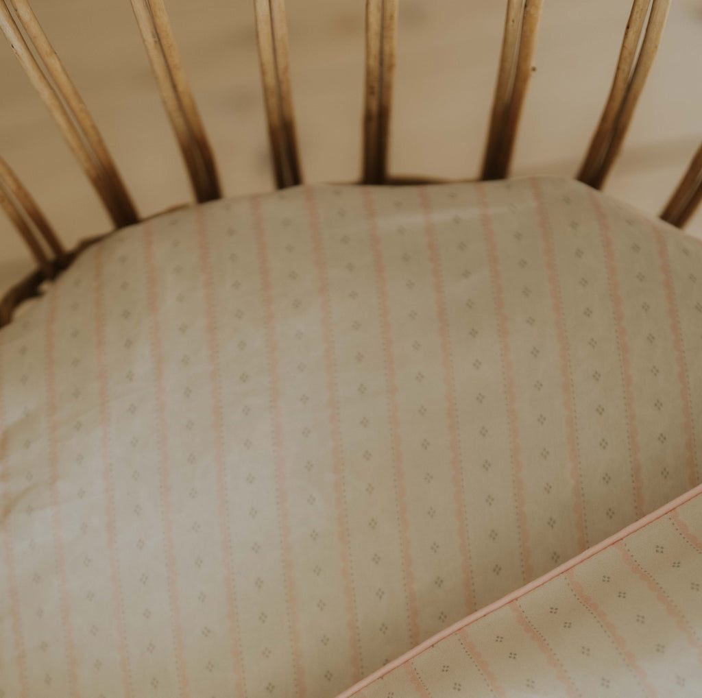 Petal Scallops Crib Sheet in Pink displayed in crib