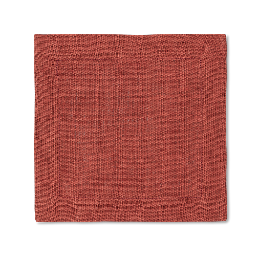 A square linen cocktail napkin in the color brick