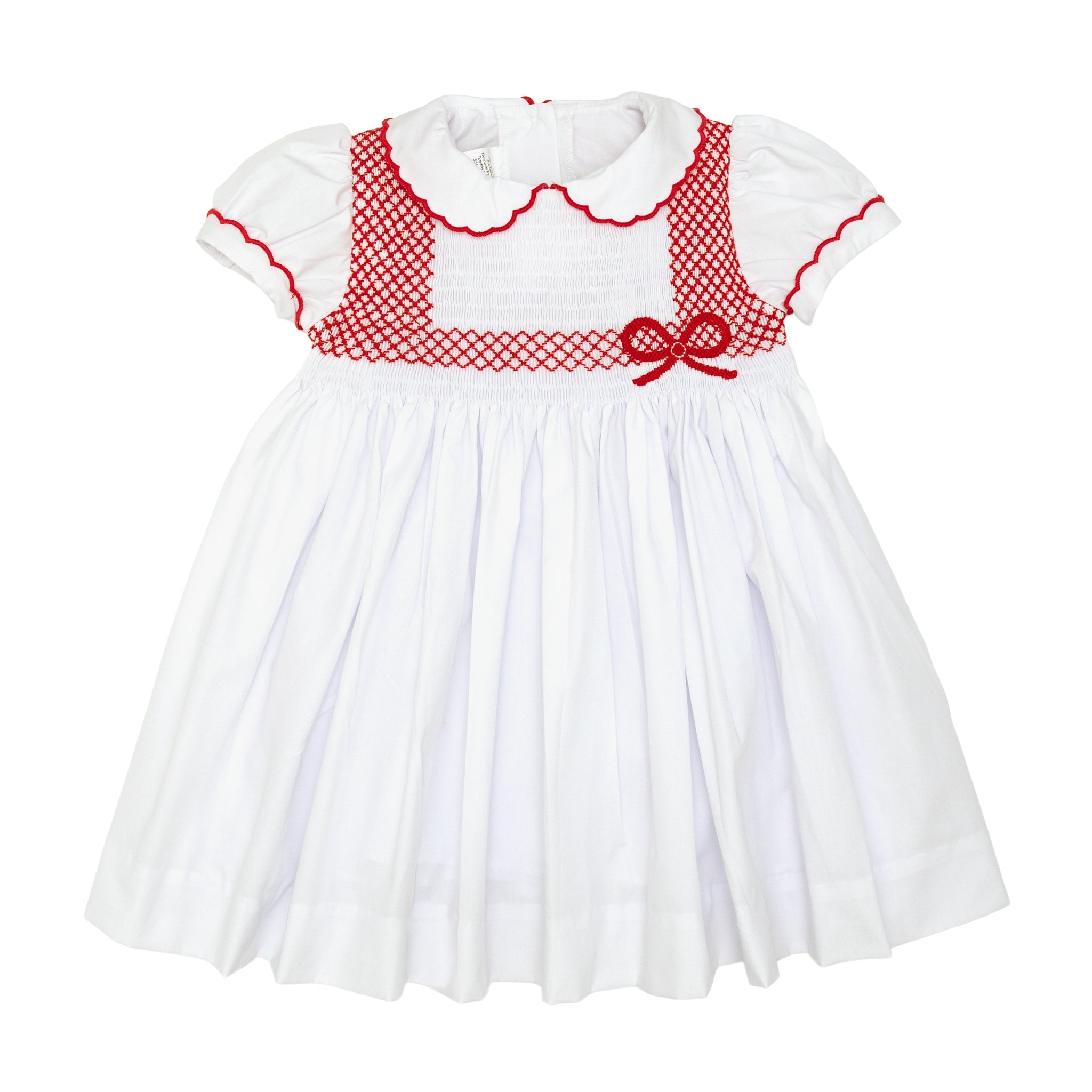 White short sleeve girls' holiday dress with red bow smocking across the chest, Peter Pan collar, and piped cuffs, classic Henry Duvall Eloise Dress for Christmas and winter family gatherings