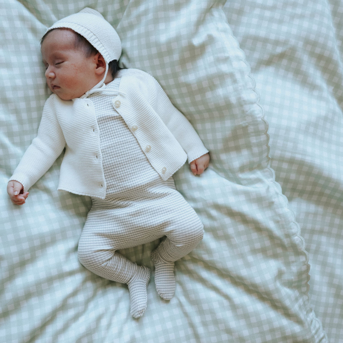 Picnic Gingham Green Baby Duvet with sleeping baby laying on top