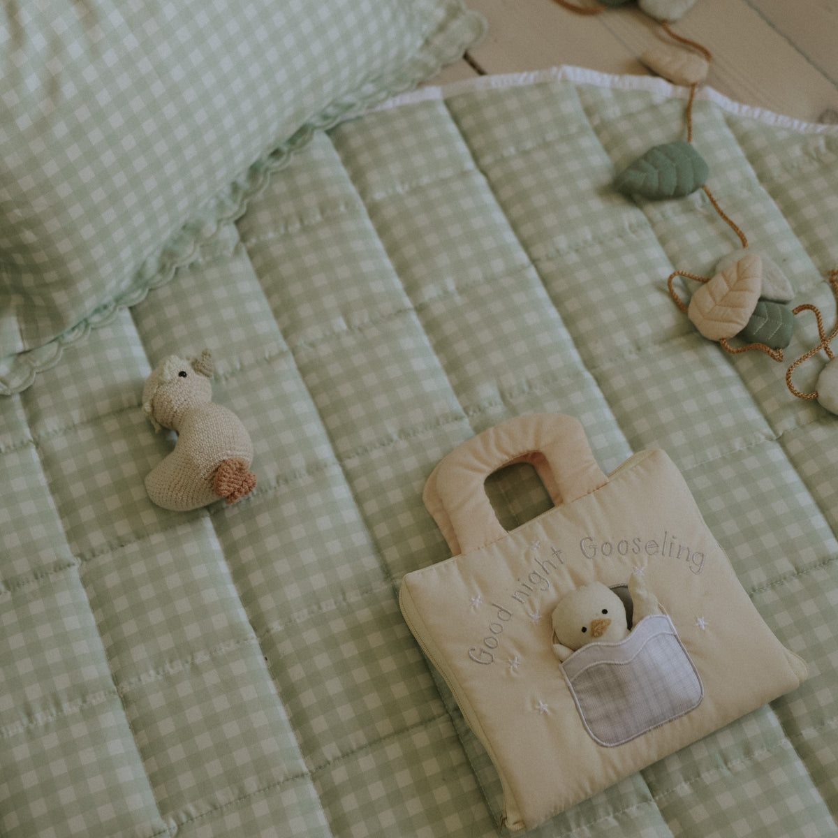 Picnic Gingham Green Playmat with Good night Gooselings book laying on top along with garland and goosie