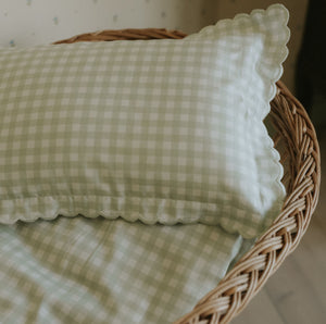 Picnic Gingham Green Toddler Pillow placed in crib