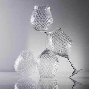 Phoebe clear optic universal and stemless tulip crystal wine glasses from Caskata on a grey backdrop.