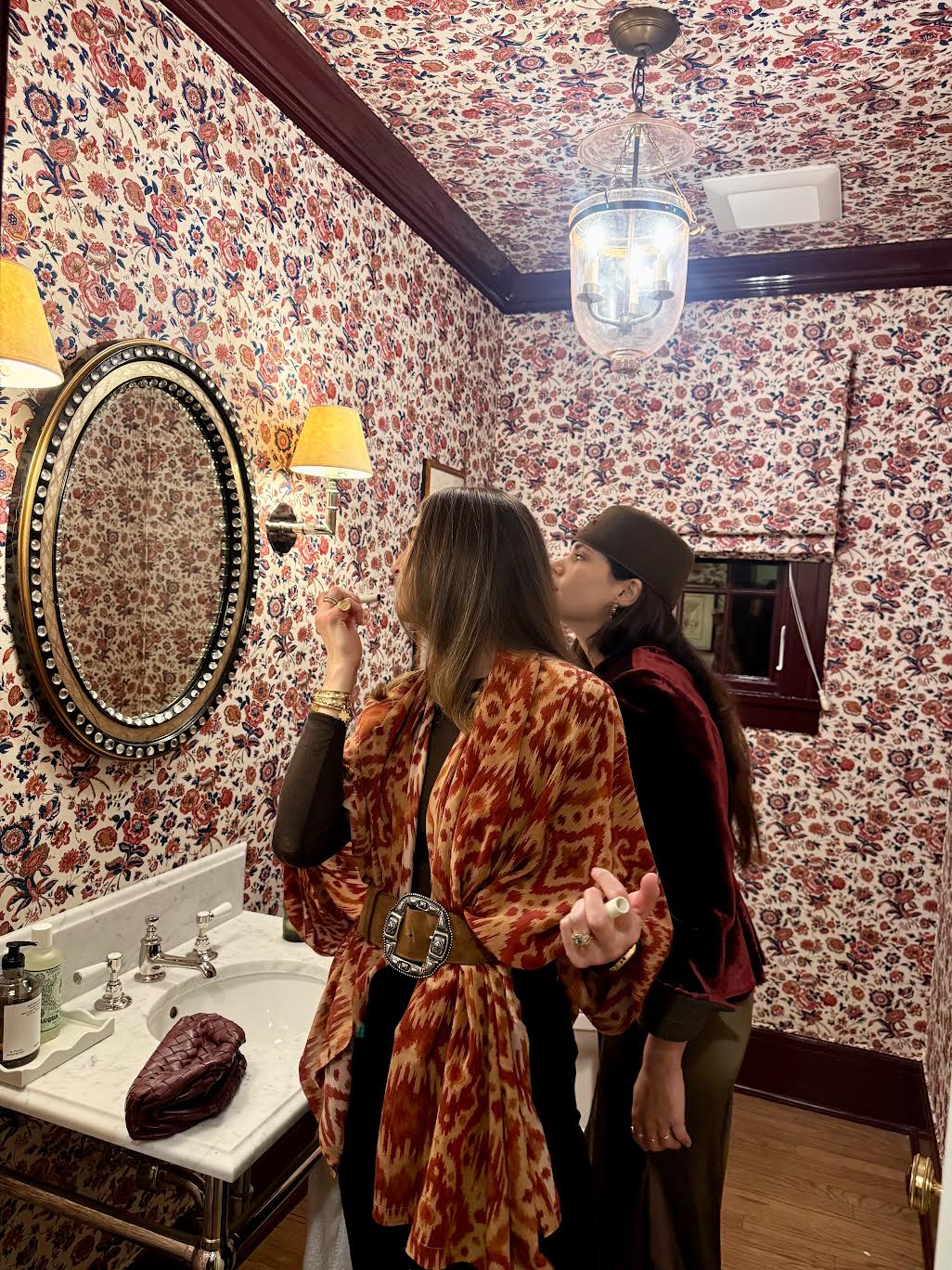 Back view of Annabelle Pareo in Red Ikat showcasing its draped wrap styling in a patterned bathroom