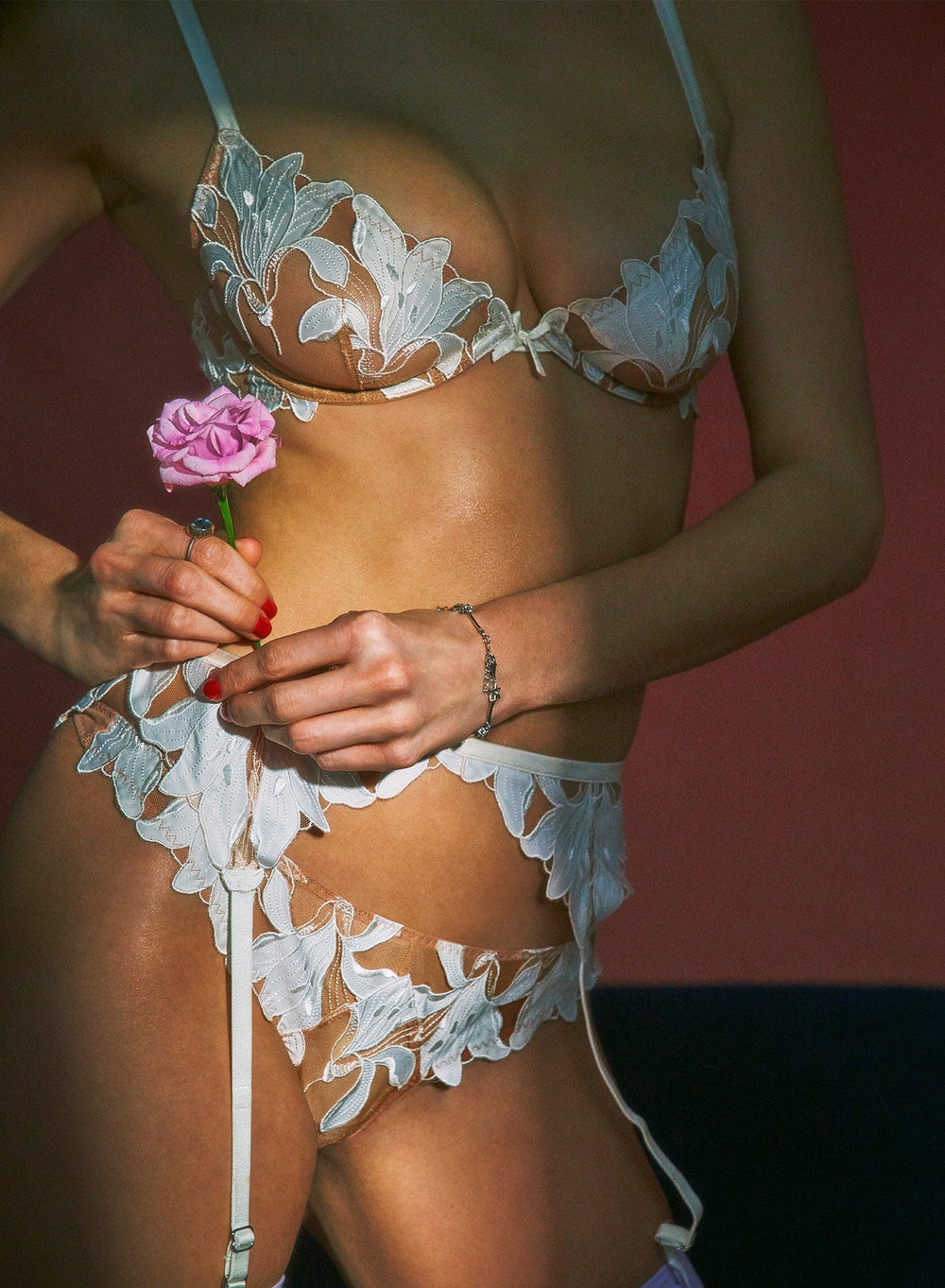 Front close-up of ivory Lily Embroidery hipster thong on model showing sheer floral embroidery, scalloped edges and garters