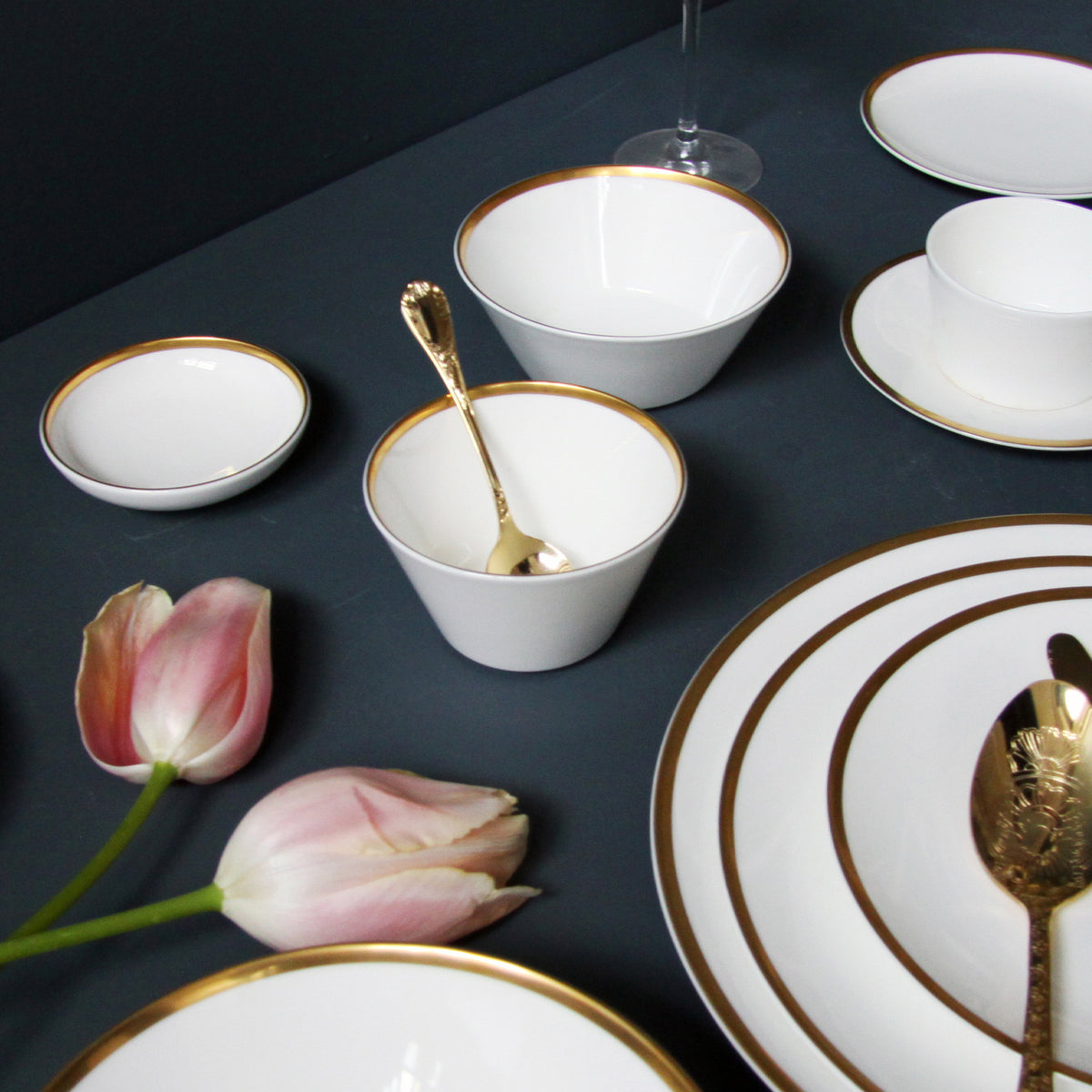 Angled view of Golden Edge cereal/soup bowl showing white fine bone china with hand-painted 24K gold rim on dark tabletop