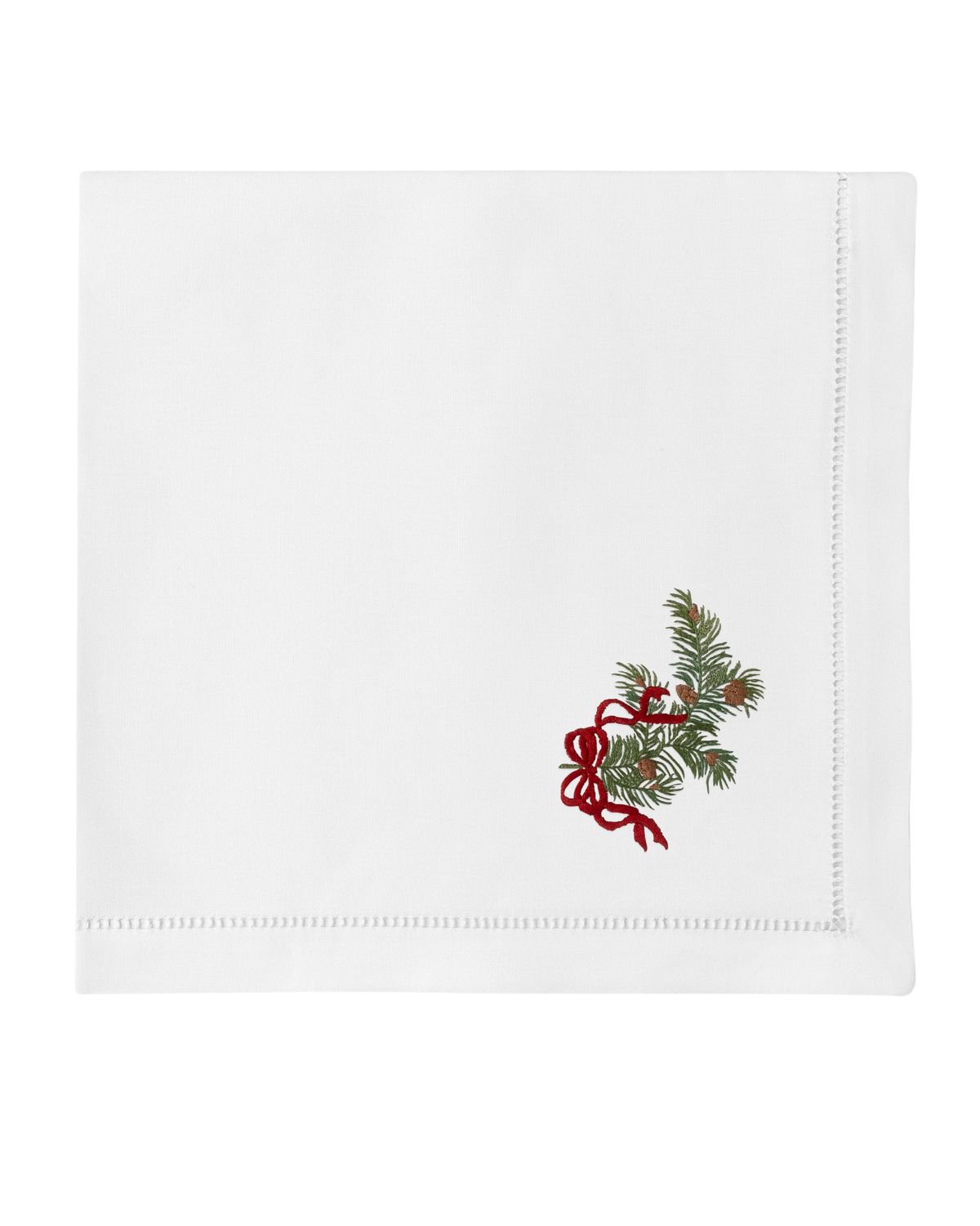 Front view of Pine Bough Ribbon Napkin showcasing embroidered pine boughs and red ribbon on white cotton with hemstitched border