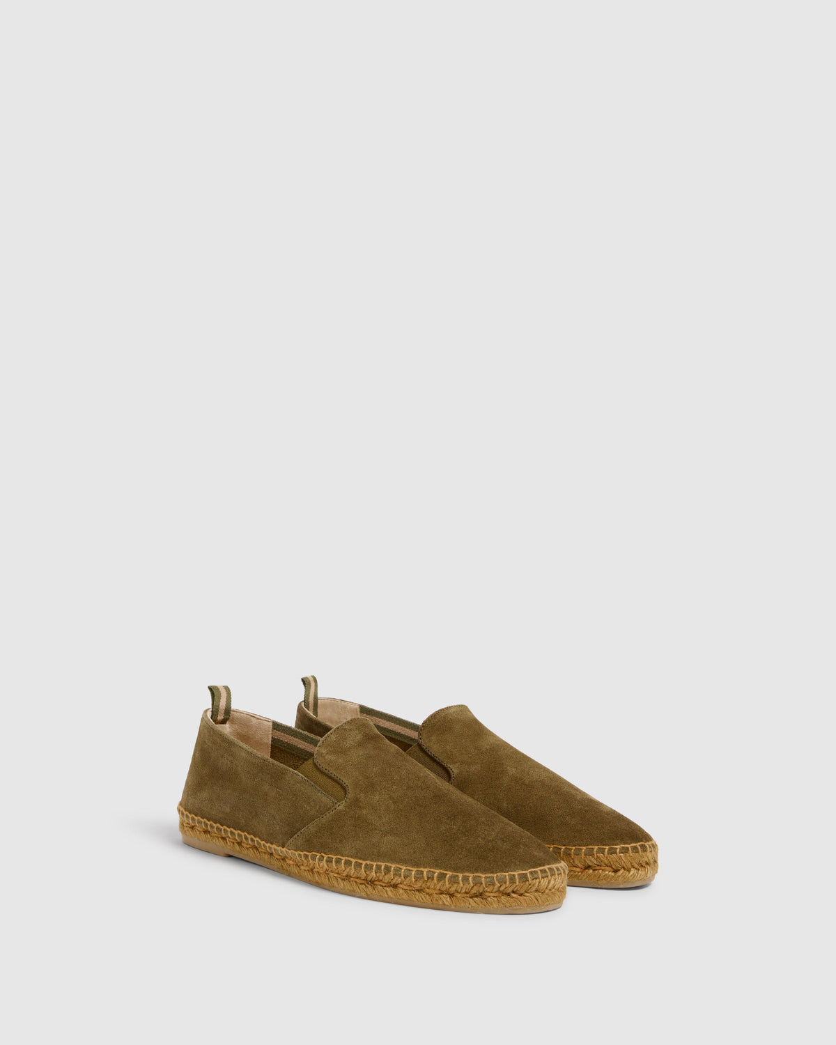 Three-quarter view of Men’s Joel espadrilles in olive green suede showing elastic side goring and braided jute sole on light gray background