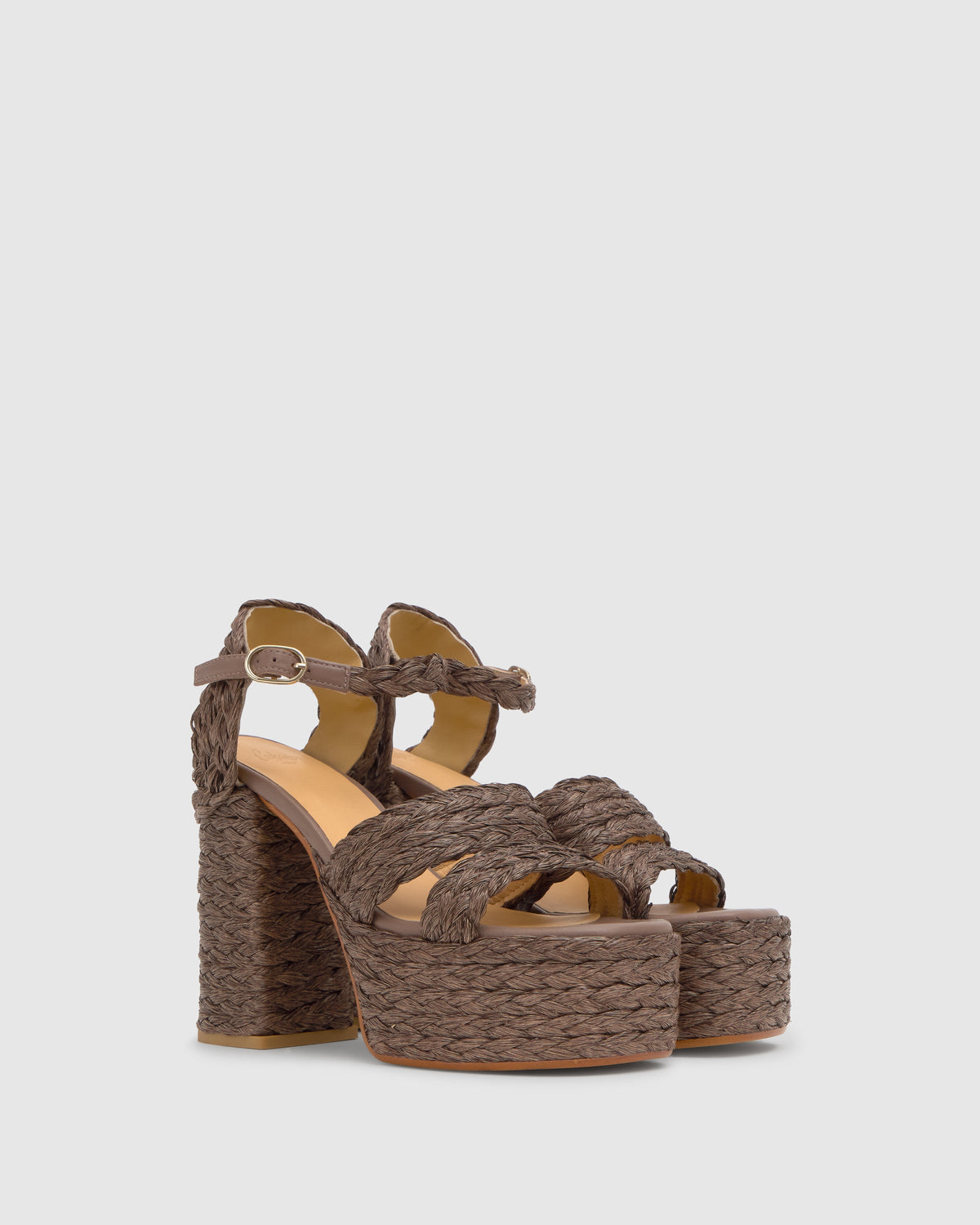Three-quarter view of Fresa platform sandal in taupe raffia with braided straps and ankle buckle on gray background