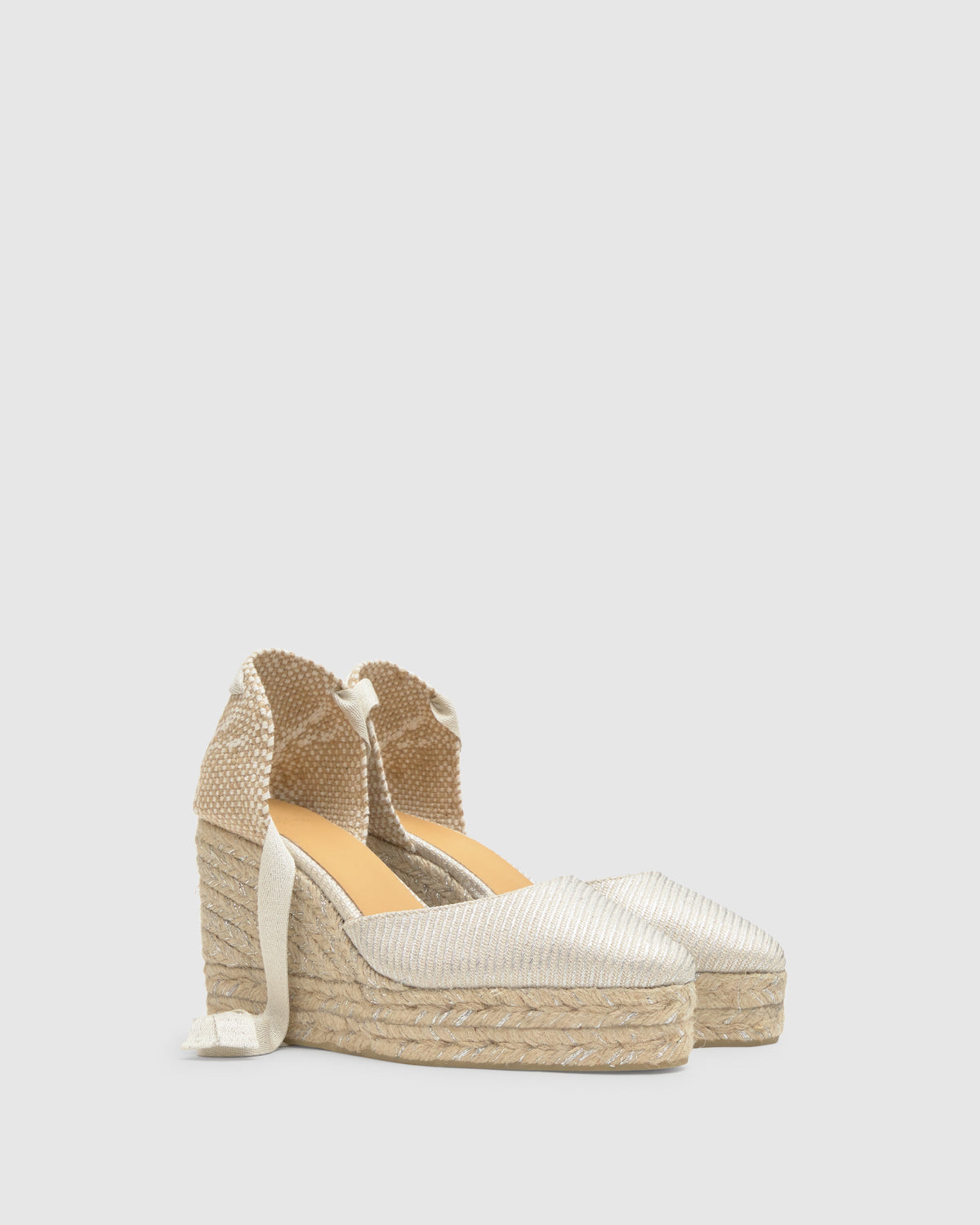 Three-quarter view of Joyce 8ED espadrille in silver with metallic upper, ribbon tie and jute double-platform wedge
