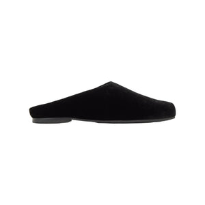 Side view of Gada black velvet slipper showcasing its flat open-back silhouette on a white background