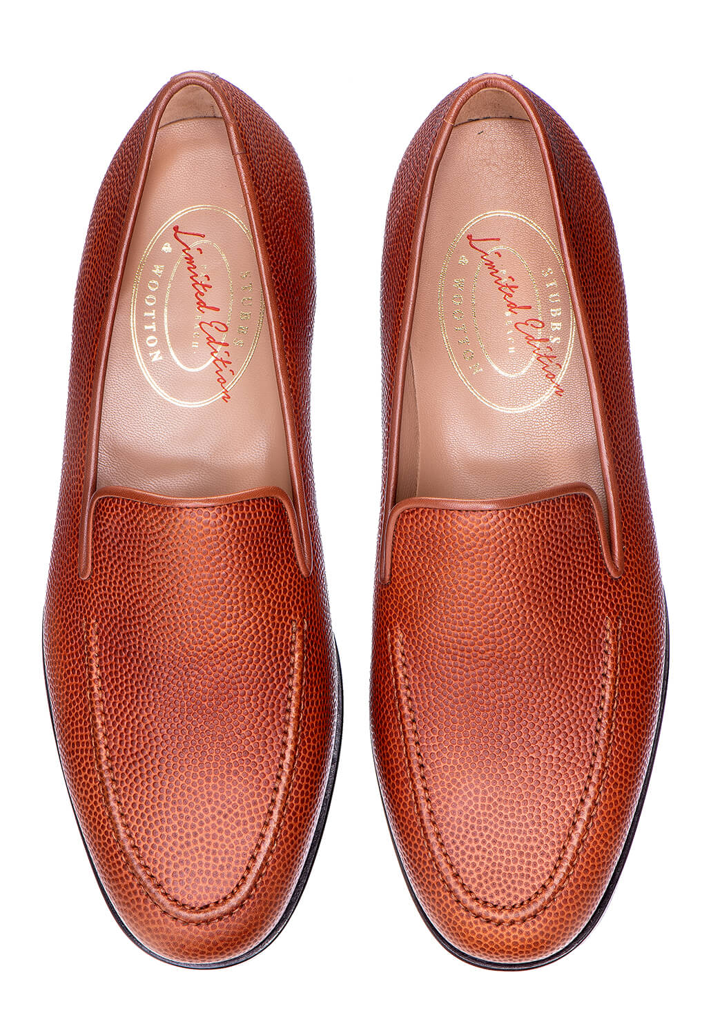 Overhead view of Men’s Football Leather Venetian loafers showing pebble-grain football leather in orange on white background