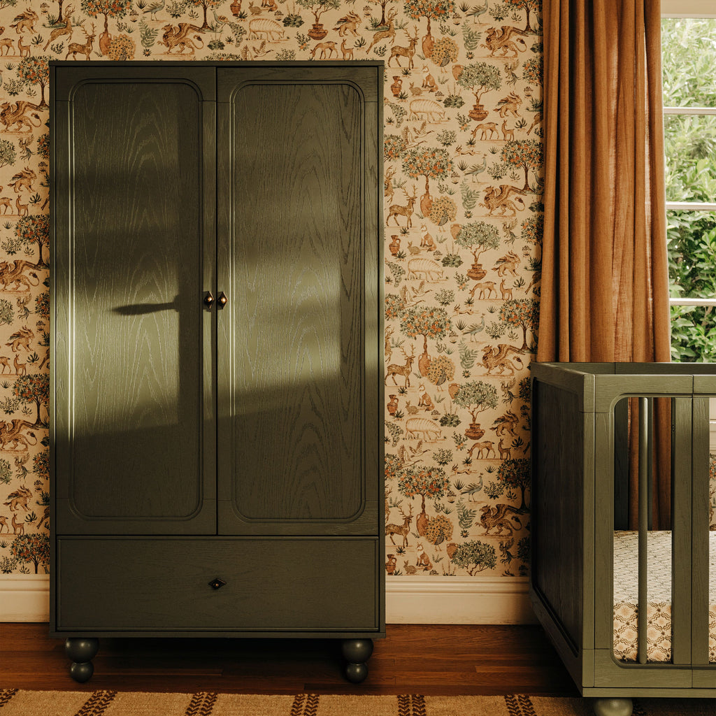 Front view of Astre Assembled Armoire by Nate Berkus in Archival Elm showcasing paneled doors and lower drawer in a floral room