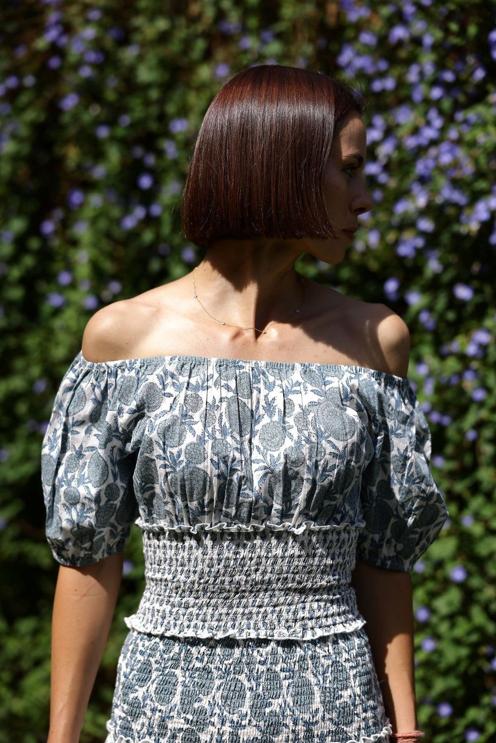 Front view of Tahiti Blouse in blue on model showing fitted smocked waist, off-the-shoulder neckline and puff sleeves