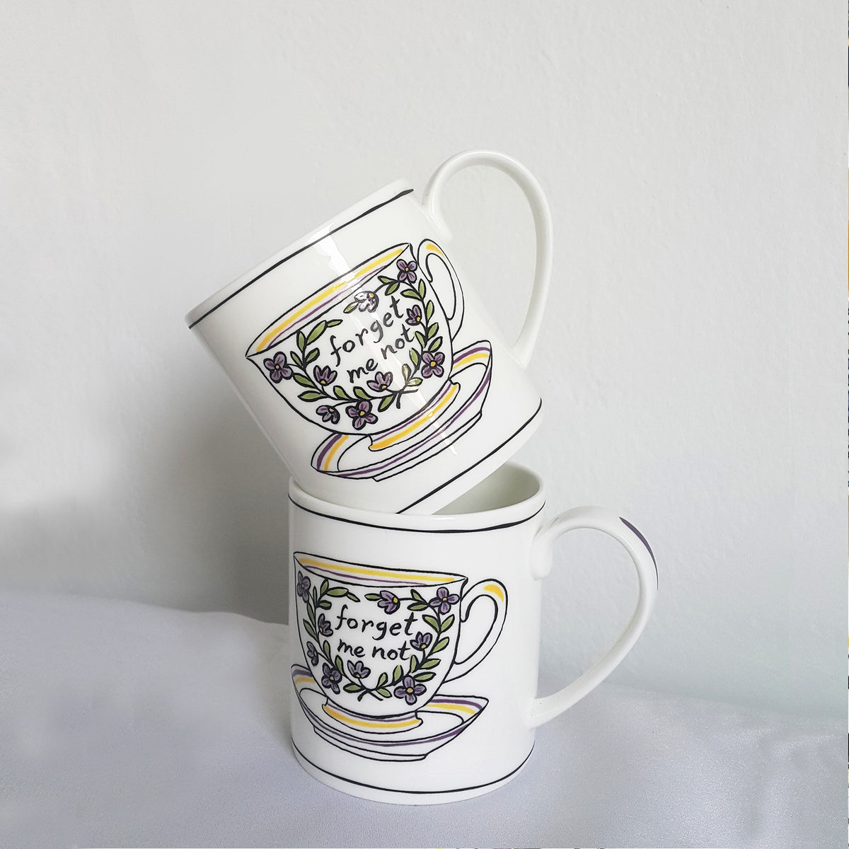 Front and angled views of Heritage Forget Me Not Mug showcasing floral decals and colorful stripes on a white background