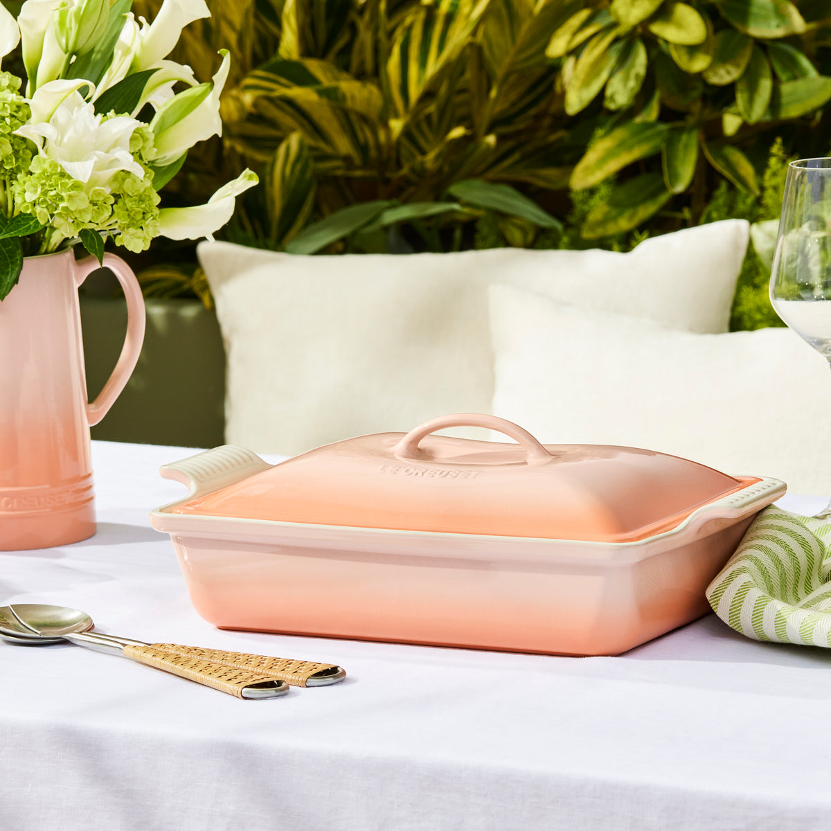 Three-quarter view of Heritage Covered Rectangular Casserole in Peche showcasing its lidded stoneware design with flowers and tableware
