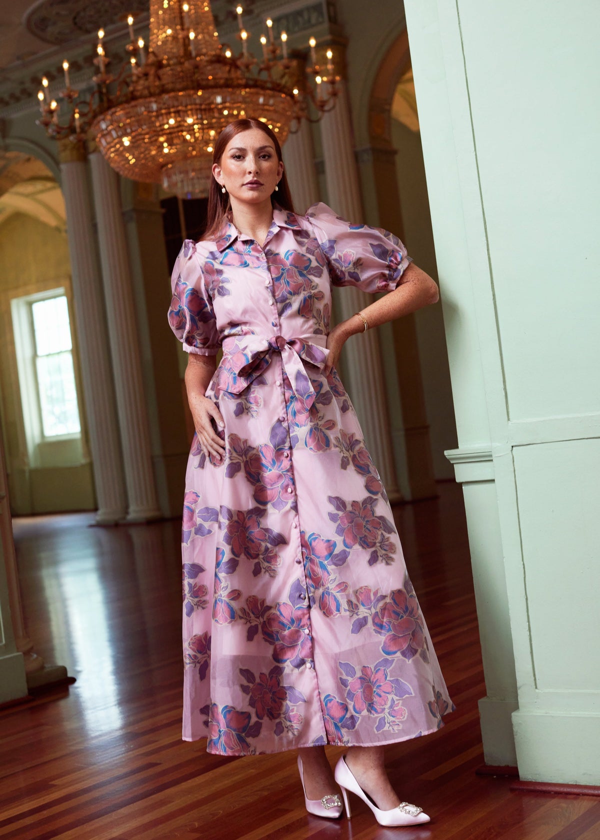 Front view of Charlotte Gown in Pink Peony Organza with covered buttons and self-tie belt on a model indoors