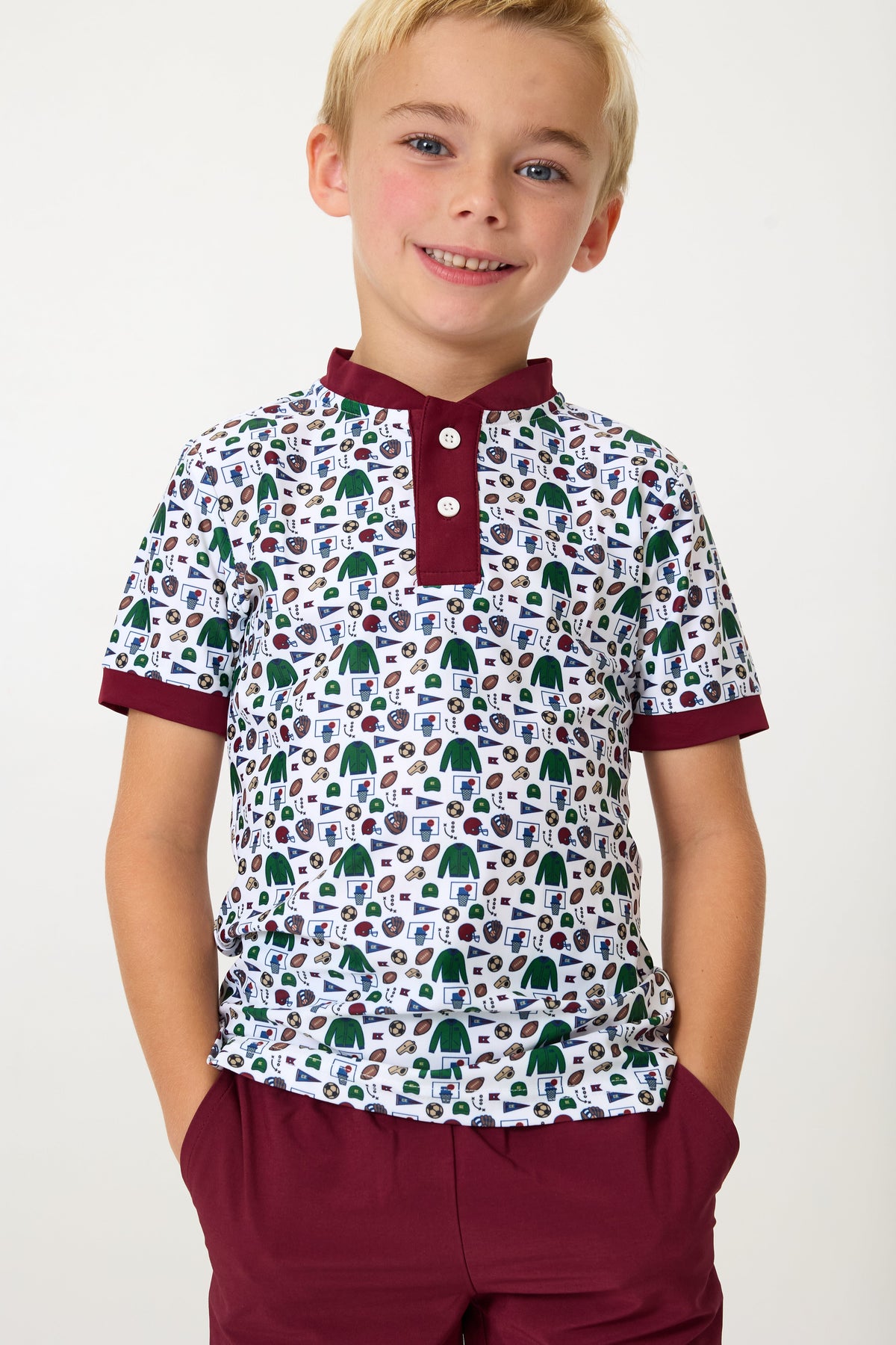 Front view of Champions Blade Shirt on child model with maroon blade collar and cuffs, short sleeves, and white sports-print