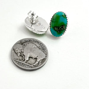 Close-up of Sonoran Gold stud earrings showcasing green turquoise and sterling silver settings with a coin for scale