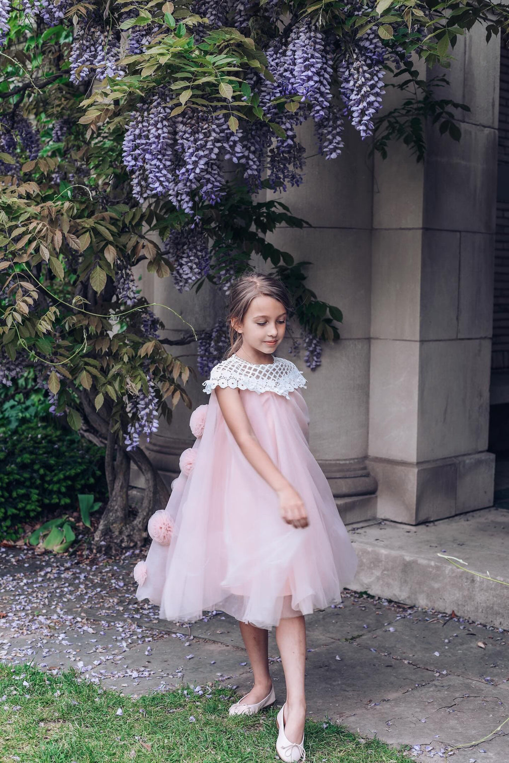 Girls pink tulle dress with flower details styled for a special occasion 