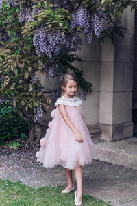 Girls pink tulle dress with flower details styled for a special occasion 