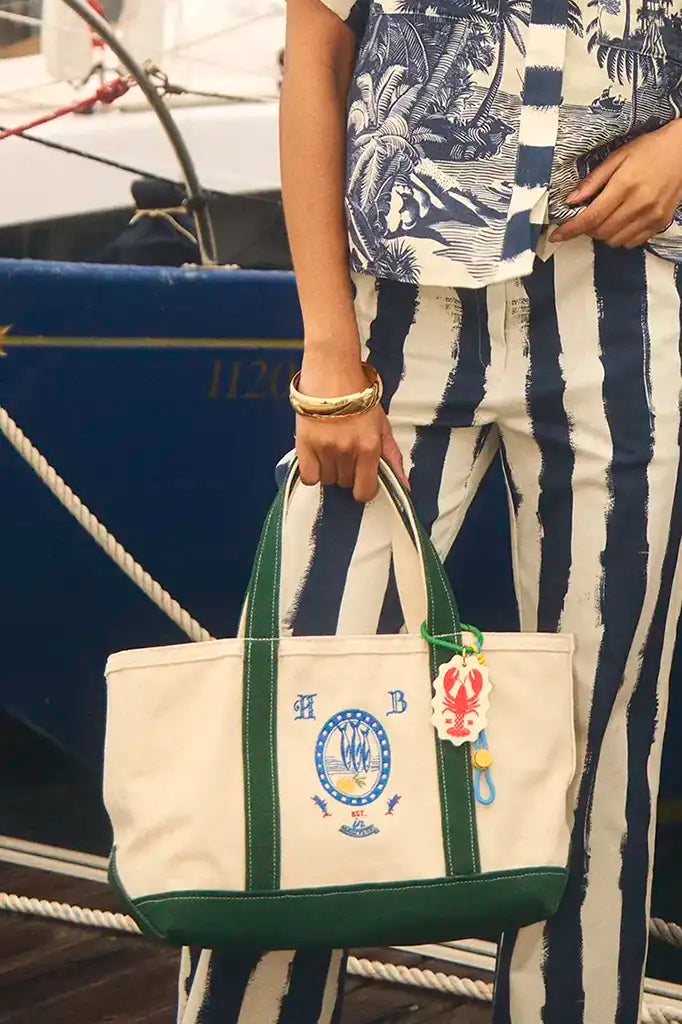 The medium canvas tote bag with green handles and fish motifs.