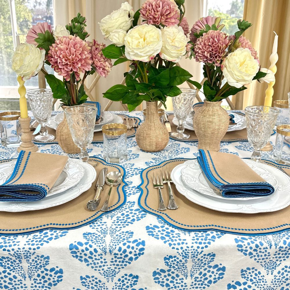 Elegant table setting with floral centerpieces, patterned tablecloth, and decorative plates. luxury embroidered placemat and napkins
