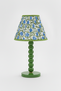 10-inch pleated blockprint empire lampshade in Araminta Blue mounted on a green ceramic lamp base with stacked spherical accents.