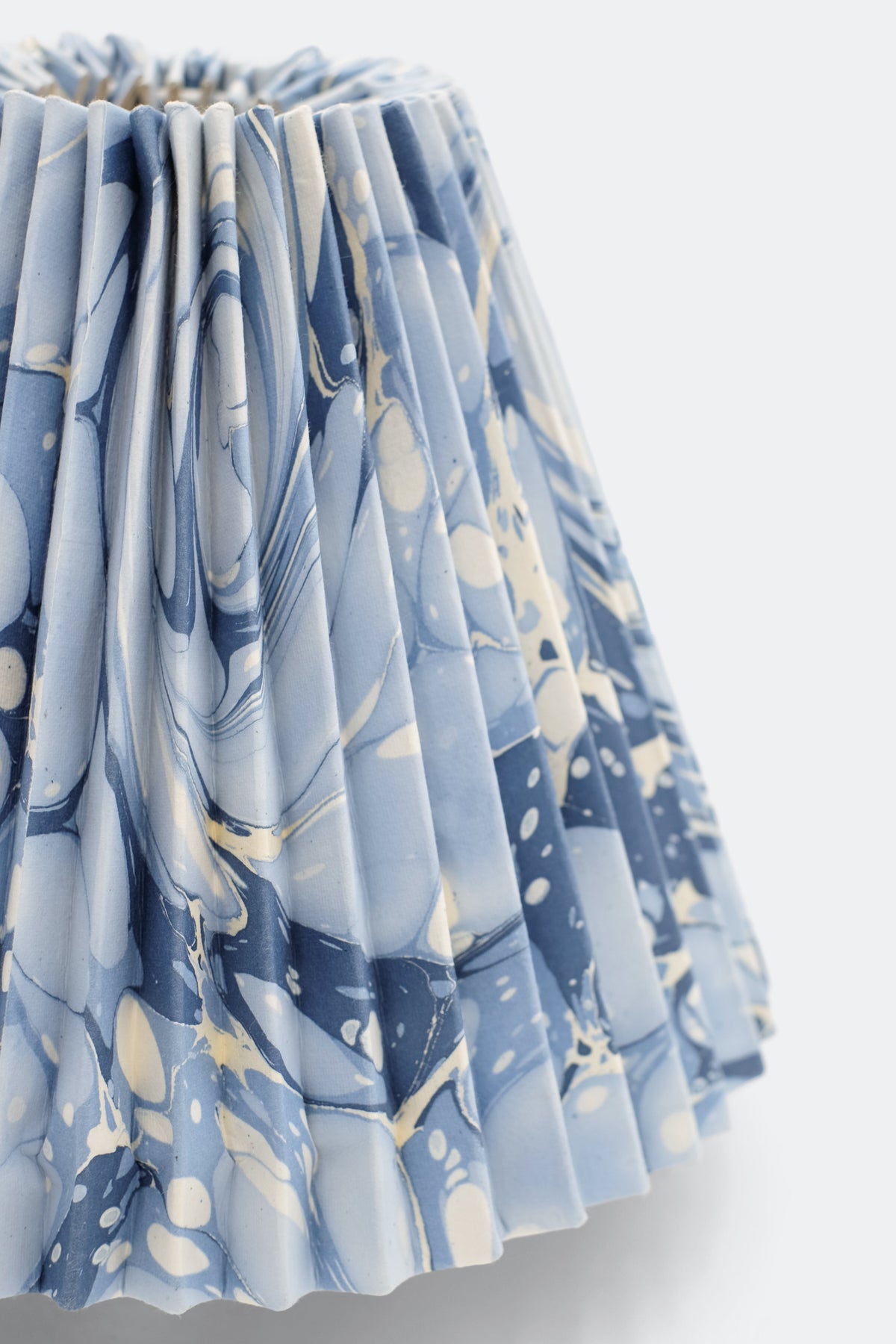 Close-up of hand-marbled pleated lampshade with ocean wave pattern on blue-gray fabric - Inner Child