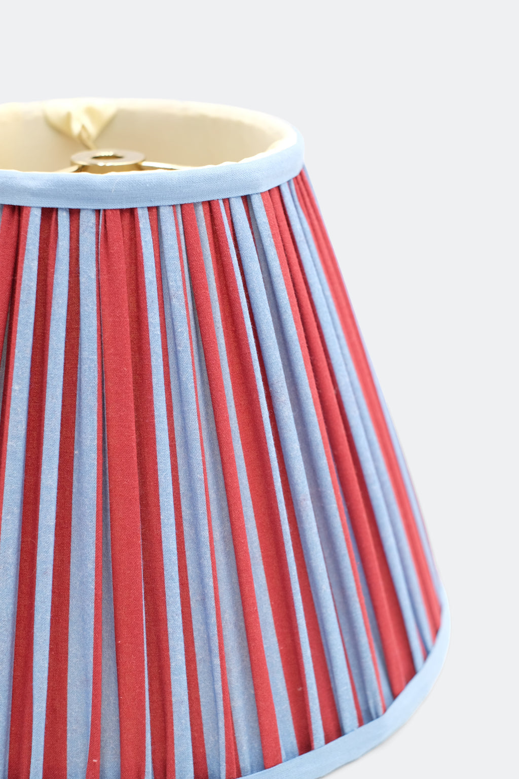 Close-up of 10-inch pleated blockprint empire lampshade featuring red and blue vertical stripes with light blue trim