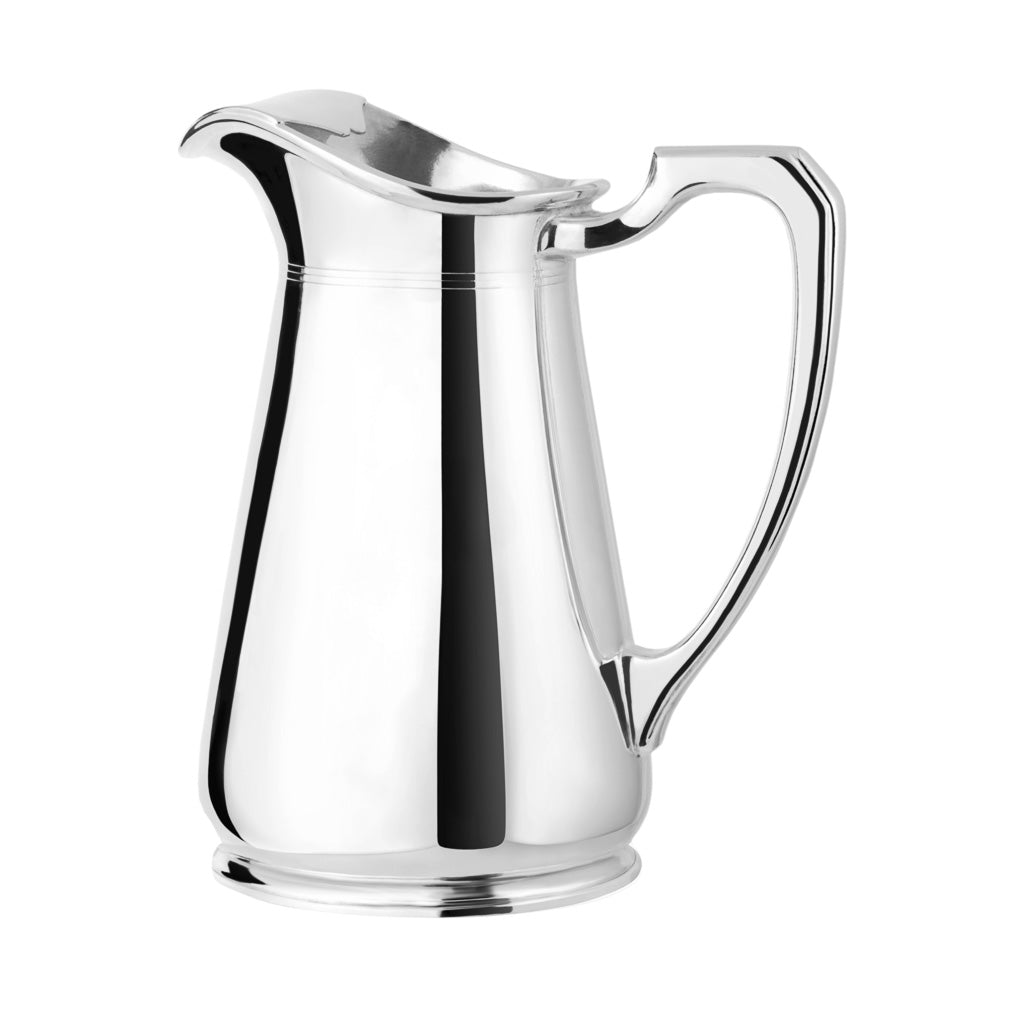 Three quarter view of vintage silver-plated water pitcher showing tapered body, mirror finish, curved spout and angular handle on white background