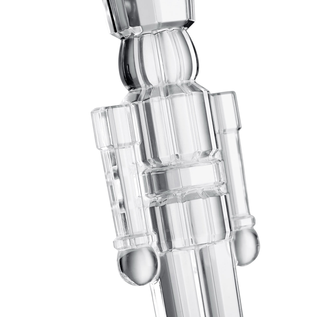 Close up of clear crystal standing nutcracker ornament showcasing bold geometric cuts and smooth polished finish on white background