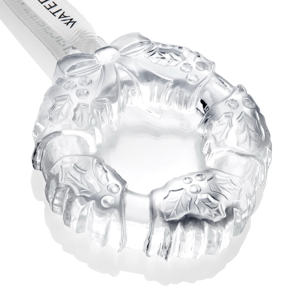 Close-up of Waterford mini wreath crystal ornament showing carved holly leaves, berries, and ribbon detail on white background
