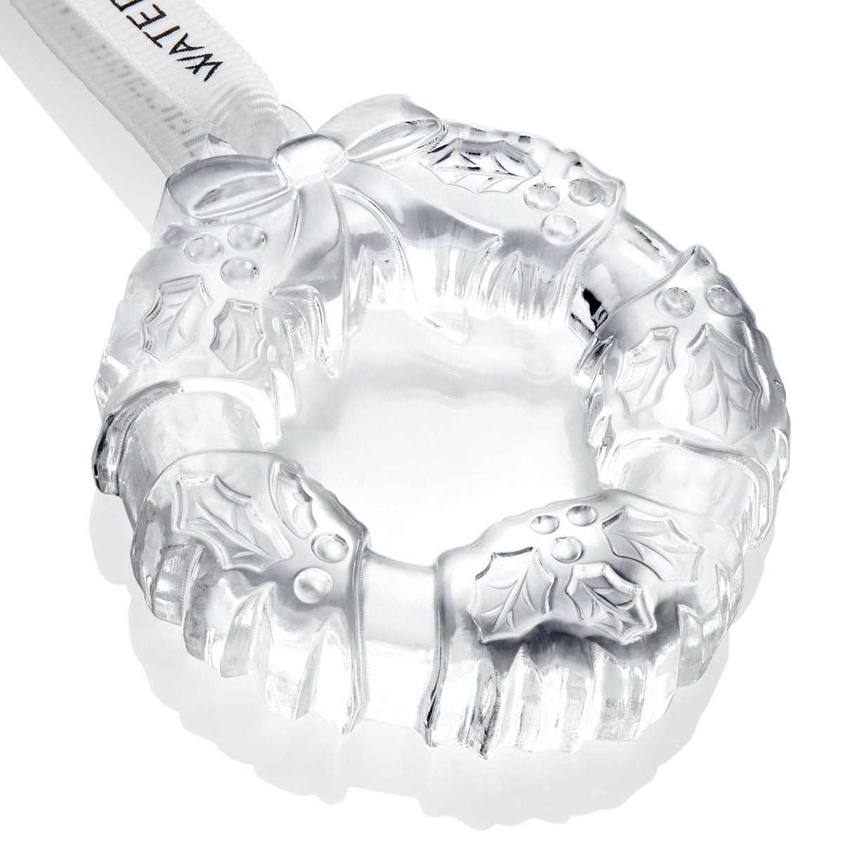 Close-up of Waterford mini wreath crystal ornament showing carved holly leaves, berries, and ribbon detail on white background