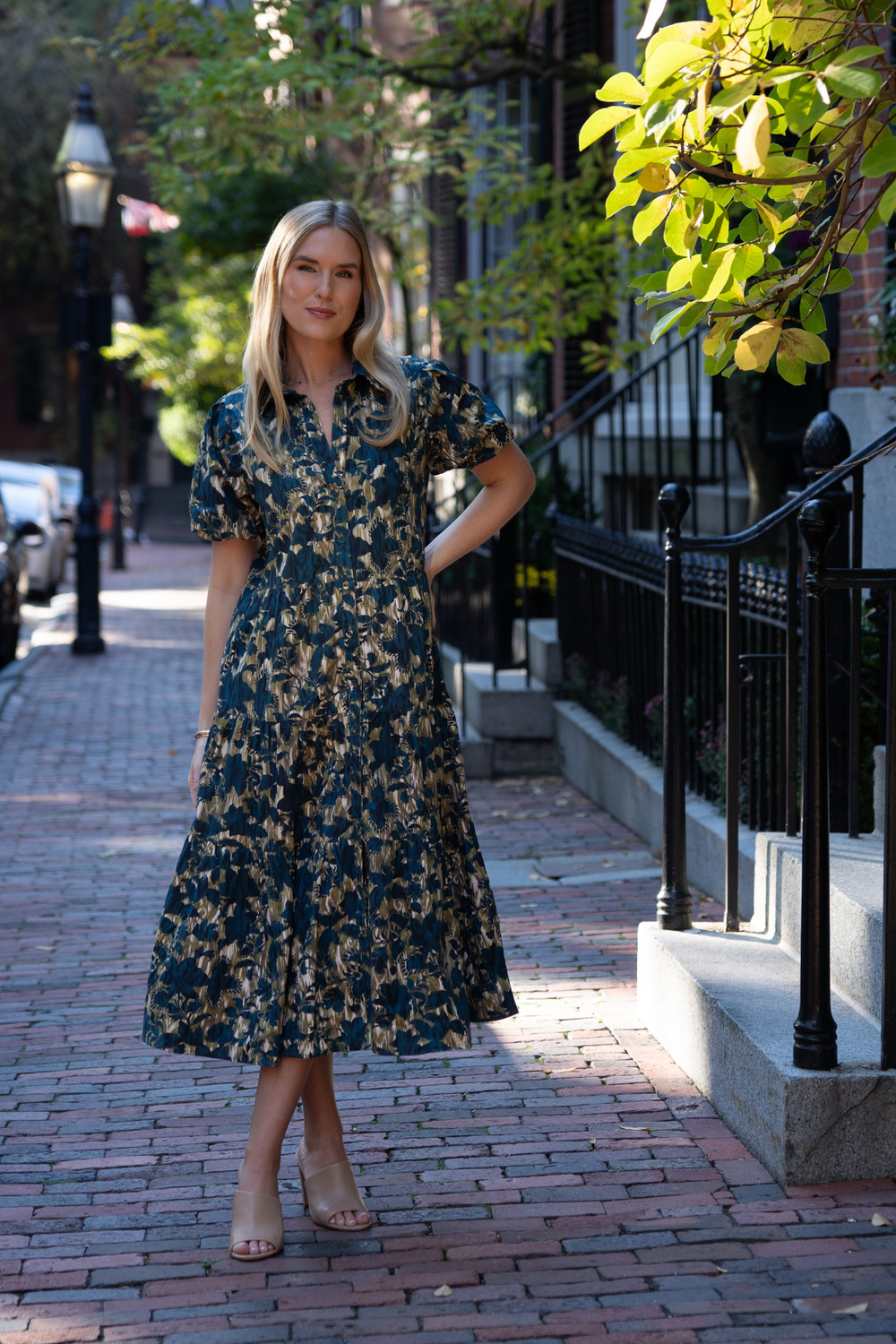 Front view of Mirasol dress in Cirque Terre Navy on model, moss green and navy print with puff sleeves and tiered midi skirt