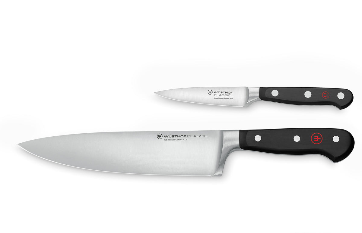 Top view of Wusthof Classic 2-piece set: chef’s knife and paring knife with full-tang triple-riveted black handles on white