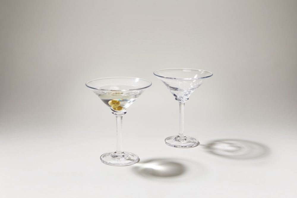 Two Woodbury Martini glasses, one with a martini and olive, showing squared creases and textured bowls on a light background