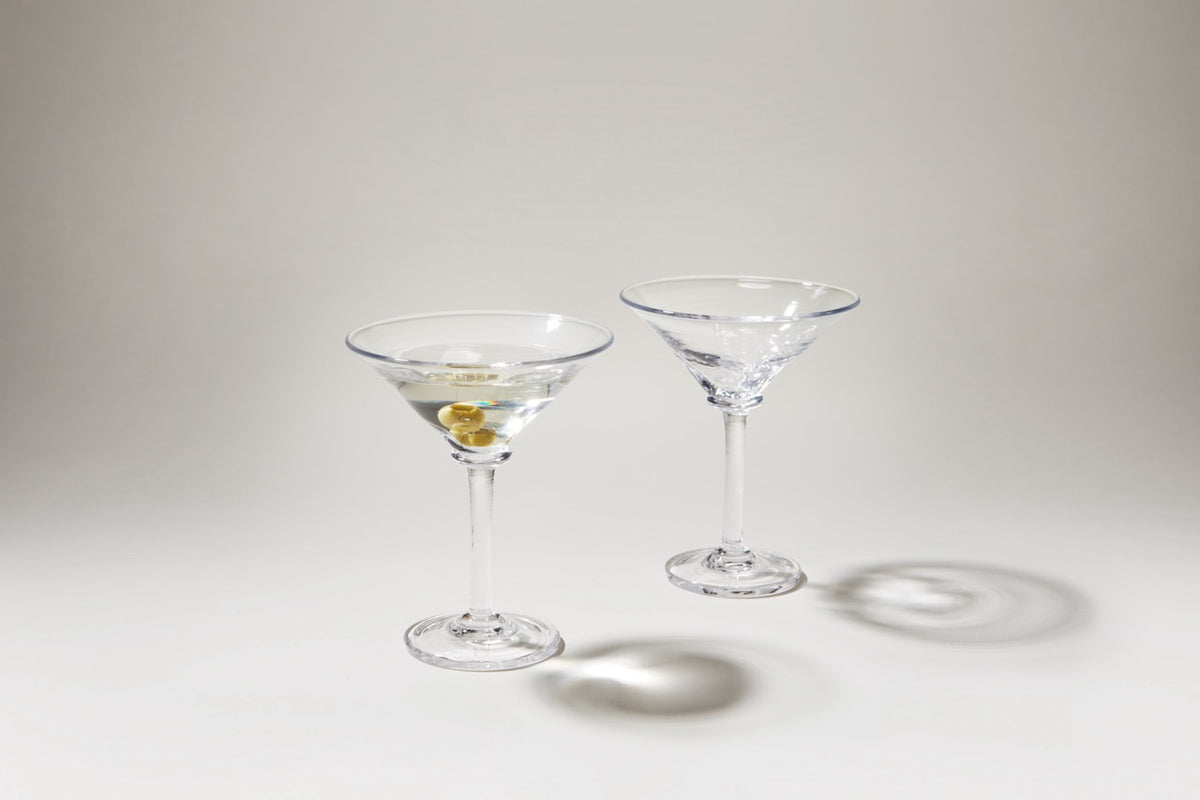 Two Woodbury Martini glasses, one with a martini and olive, showing squared creases and textured bowls on a light background